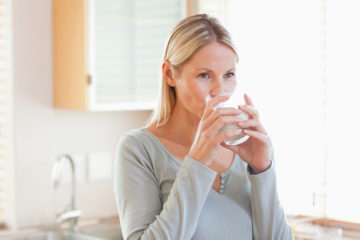 Woman in the kitchen drinking water