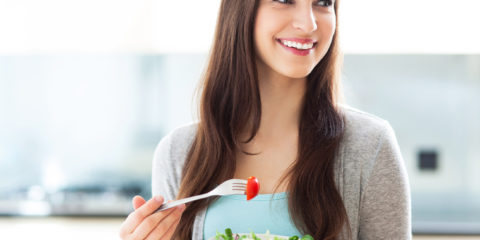 braunhaarige Frau mit Schüssel Salat in der Hand