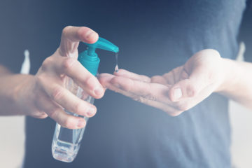 Male hand using sanitizer to disinfect from Covid-19 bacteria.